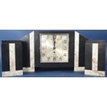 An art deco marble clock garniture, the case with shaped outline, the side ornaments of