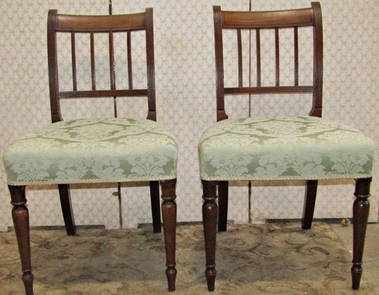 A set of six Regency mahogany dining chairs with reeded stick backs over upholstered seats raised on