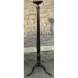 A mahogany torchere in the Georgian style, the reeded column with wheatear detail, raised on
