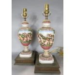 A pair of 19th century china vases with frolicking cherub decoration, converted into table lamps.
