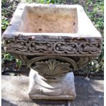 A cast composition stone square tapered planter with foliate detail and square platform base (