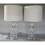 A pair of modern glass table lamps of triple bulbous shape both with shades.