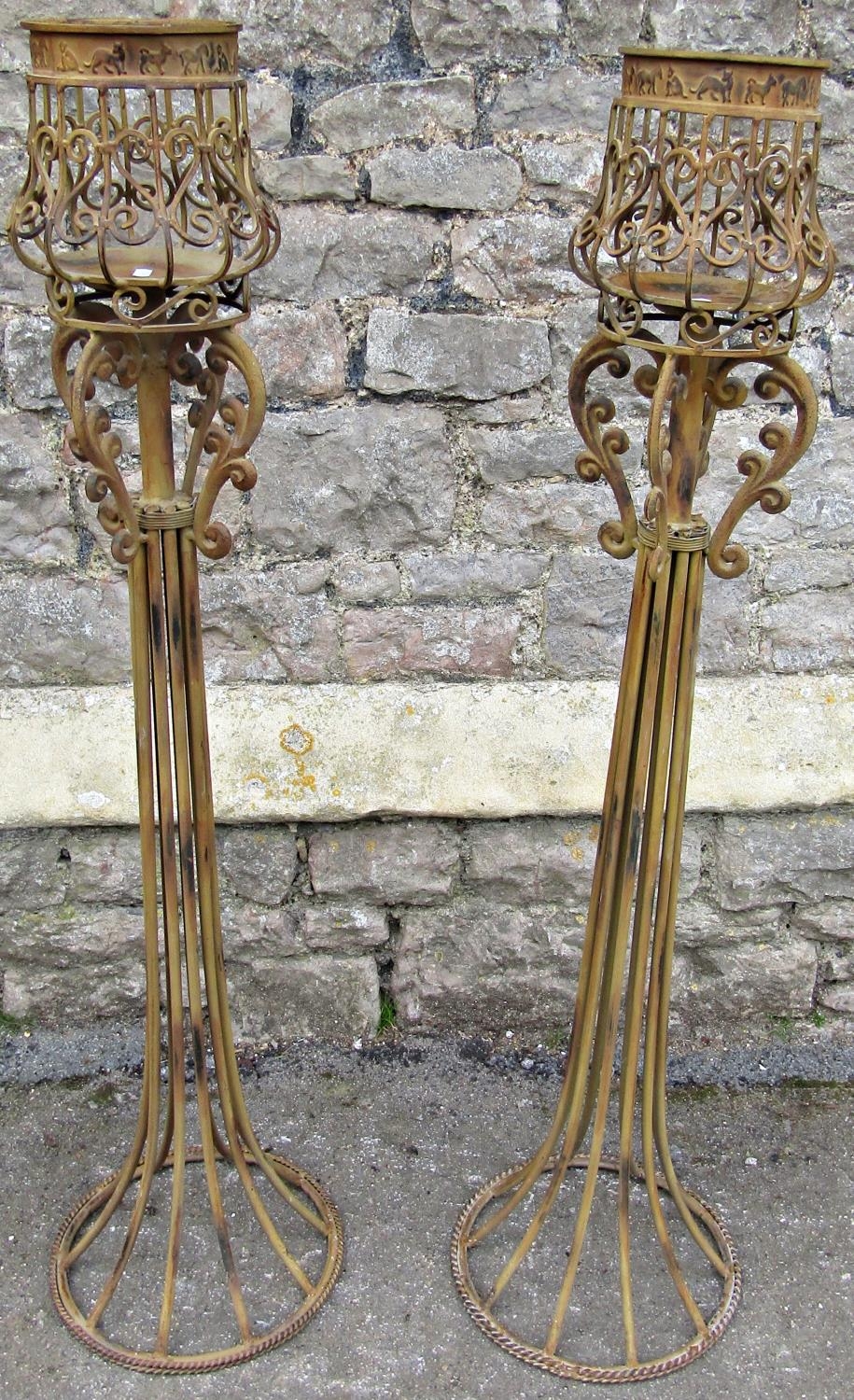 A pair of contemporary painted light steel floorstanding candle lanterns with open scrollwork detail