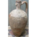 A buff coloured terracotta amphora with simple incised comb detail (af one handle missing), 55 cm