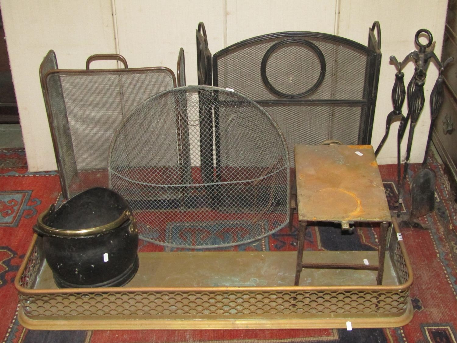 One lot of antique and later fireside ware/tools to include a pierced brass fender, two folding