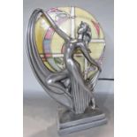 An Art Deco style lamp of a woman posing in front of a circular stained glass window.