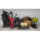 A variety of cast iron doorstops in the form of a black goose, a pig, a pear tree, and two black