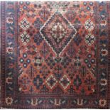 A Joshehan rug with a stepped central medallion with stylised flowers and trees on a pink ground,