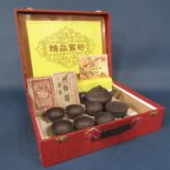 A boxed set of oriental terracotta type teawares with matt finish comprising teapot, six tea bowls