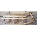 A traditional sledge principally in ashwood with iron tipped runners marked Davos