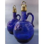 A pair 19th century Bristol blue wine bottles with grape and vine decorated stoppers.