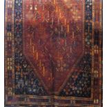 A Qashqai carpet with orange diamond shaped medallion containing stylised flowers surround by