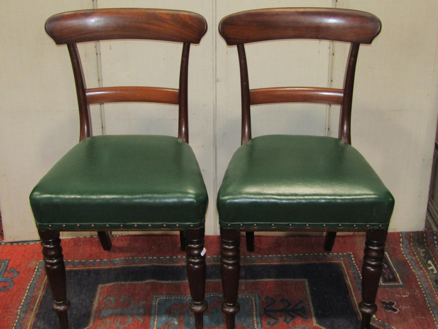 A set of six 19th century mahogany dining chairs with shaped bar backs over later green leather