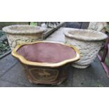 A pair of weathered cast composition stone circular planters with repeating oak leaf and acorn