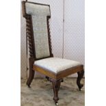 A Victorian low nursing or prayer chair with repeating floral patterned upholstered seat and T