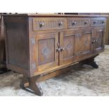 A reproduction oak dresser base fitted with three frieze drawers with stock fluted over four