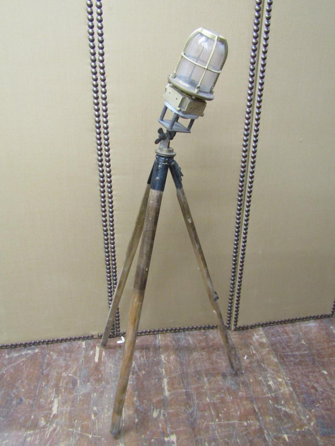 A bronze bulkhead light, later mounted on a vintage tripod