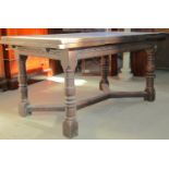 A good quality old English style oak drawer leaf dining table of rectangular form with carved frieze