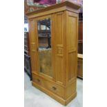 An Edwardian satin walnut wardrobe enclosed by a central three quarter length rectangular mirror