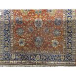 A large Persian designed carpet with all over floral pattern on a rust red ground, 360cm x 250cm