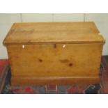 A 19th century stripped pine blanket box with hinged lid, exposed dovetail construction and ironwork