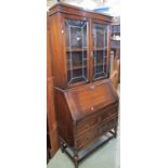 A 1920s oak bureau bookcase, the upper section enclosed by a pair of rectangular leaded light