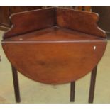 A 19th century mahogany oval drop leaf corner table with raised and shaped back raised on four cut