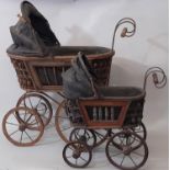 2 Victorian style dolls prams with wicker cradles mounted on metal frames, each with a black