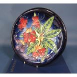 A Moorcroft charger with red and purple Rhododendron decoration with impressed and painted marks