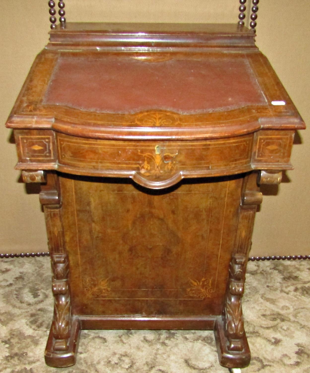 A Victorian walnut and figured walnut veneered davenport with inlaid detail and fitted with the