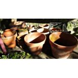 A quantity of approximately 30 terracotta flower pots of varying size and design, the largest 31