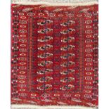 A small Turkoman rug with two rows of orange and white gul on a red ground. 105cm x 85cm