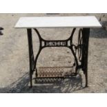 A Singer cast iron treadle sewing machine base, with later rectangular marble top, 91cm long x