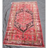 A Zanjan rug, hand knotted with central medallion on a predominately red and blue ground, 220 x