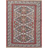 A mid 20th century flat weave carpet with four stepped medallions in shades of red, blue and