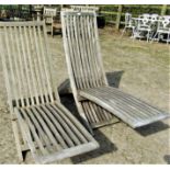 Two similar weathered hardwood low X framed folding garden chairs with slender slatted seats and