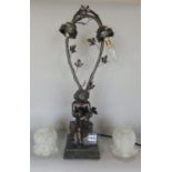 A bronze effect Art Nouveau style table lamp of a cherubic child drawing, with two twisted vine