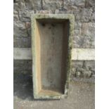 A weathered natural stone trough of rectangular form 85 cm long x 38 cm wide x 20 cm deep