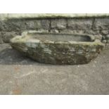 A small weathered natural stone trough of rectangular form with channelled ends (af) broken corner