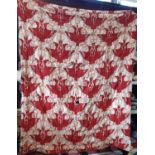 Vintage cotton quilt with a Voysey style patterned print on red ground, lined with pink cotton and