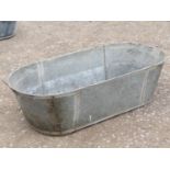 A galvanised oval two handled tin bath, 120 cm long x 53 cm wide x 33 cm deep