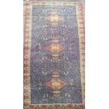 A large country house size carpet with 3 central medallions on a blue busy floral and bird pattern