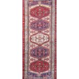 A Heriz runner with five interlocking medallions with a stylised floral border. 315cm x 75cm