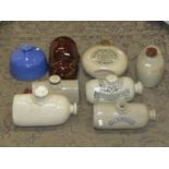 A box of 19th century and later ceramic and stone hot water bottles some with printed script