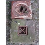 A weathered natural stone square drain cover/surround with cast iron grill 40 cm square together