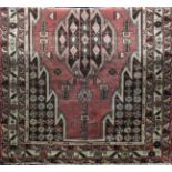 A Mazlaghan rug with a central stepped medallion within larger stepped area, with stylised flowers