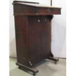 A vintage stained pine clerks/school desk with hinged slope and over a cupboard to reverse and
