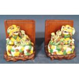 A pair of carved hardwood book ends surmounted by a pair of porcelain Temple dogs and young, 5 cm