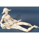 A Lladro porcelain figure of a seated Harlequin playing a guitar, approx 45cm long x 25cm high