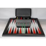 A mirrored backgammon board, 59 x 52cm, with a box of counters, shakers and 3 dice (one die missing)